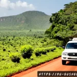 기니에서 장거리 이동 시 추천 교통수단 - Photorealistic documentary travel scene in Guinea, a sturdy white 4x4 bush taxi traveling along a re...